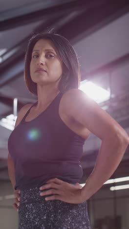 Vertical-Video-Portrait-Of-Mature-Woman-Wearing-Fitness-Clothing-Standing-In-Gym-Ready-To-Exercise